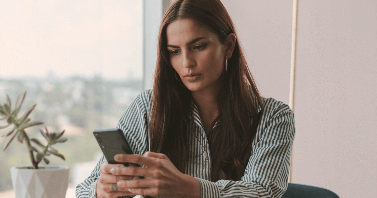 Kvinne sjekker sin egen kredittscore på mobilen